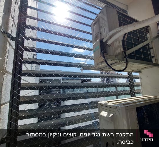 רשת יונים מותקנת על חלון עם מזגן